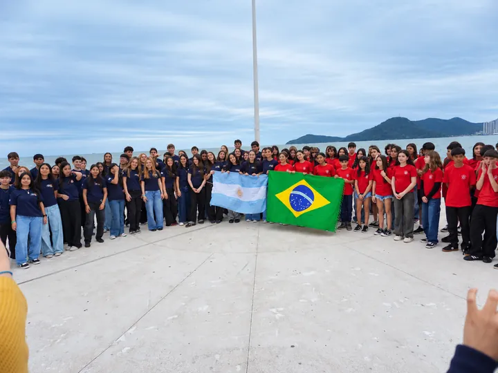Los coros del Zípoli junto al mar con las banderas de Argentina y Brasil.